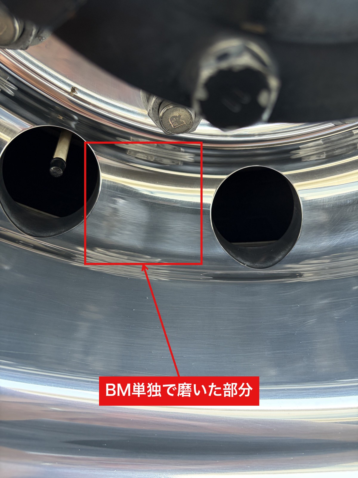右後輪ホイールの穴と穴の間を、ブルーマジック単独で磨いたスポットのアップ。鏡面に映り込みが出ている